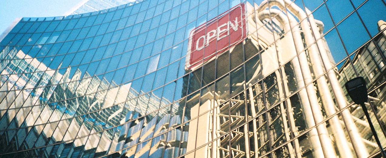 reflection of the word Open in a glass building